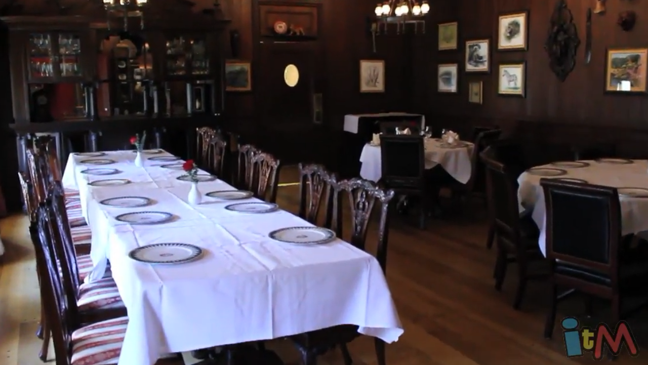 Dark wooden room with tables covered in white tablecloths