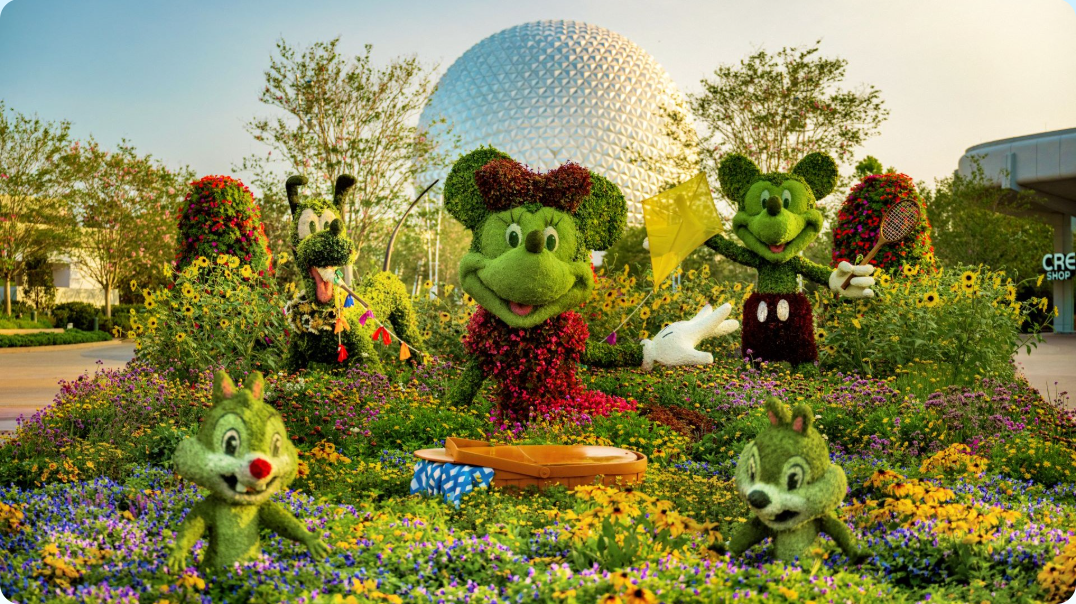 Topiaries of Mickey, Minnie, Pluto, Chip, and Dale in front of EPCOT's Spaceship Earth