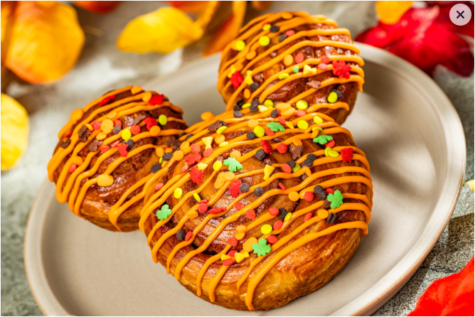 Mickey-shaped cinnamon roll with fall-colored icing and sprinkles