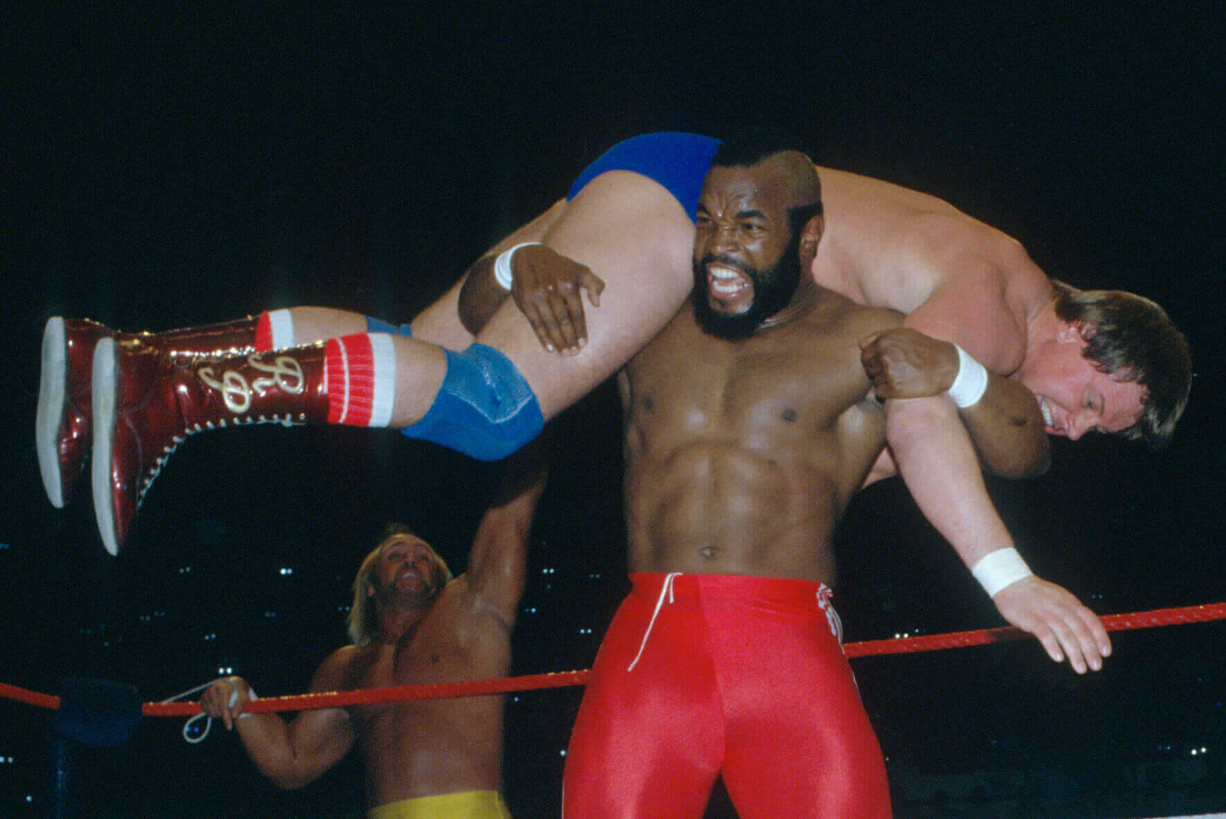 Mr T holding Roddy Piper on his shoulders while Hulk Hogan Celebrates