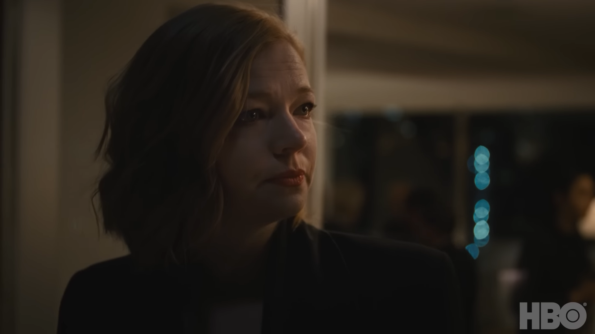 A woman stands outside at night looking angry and unimpressed