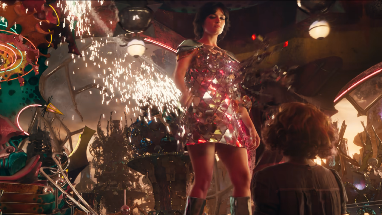 A woman in a metallic mini-dress looks with disgust at a child