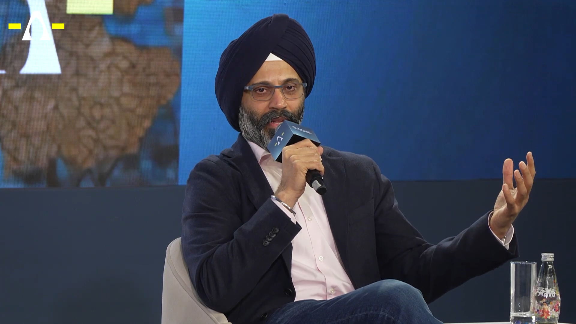 Karandeep Anand speaking into a microphone on stage