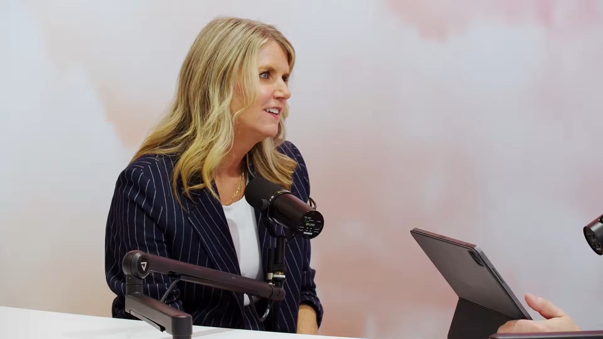 A woman smiles as she listens to an interviewer