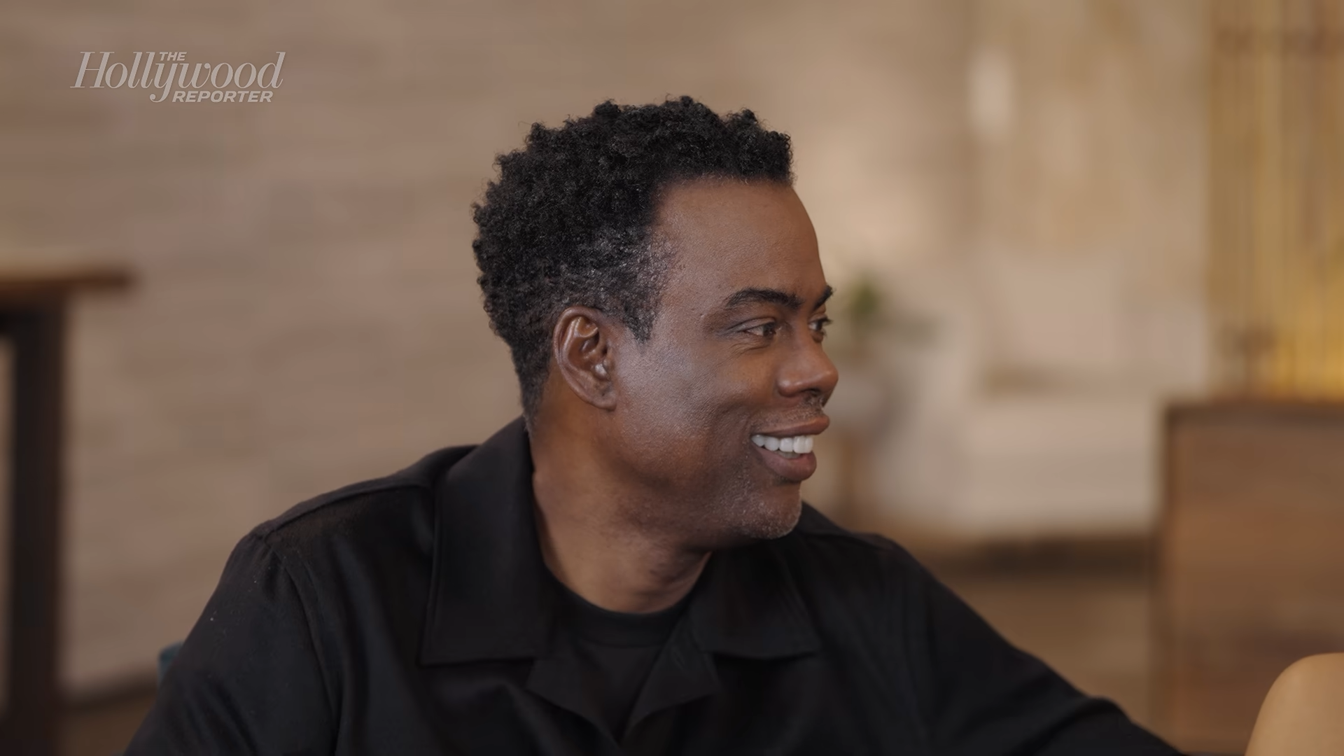 Chris Rock smiling at someone beside him