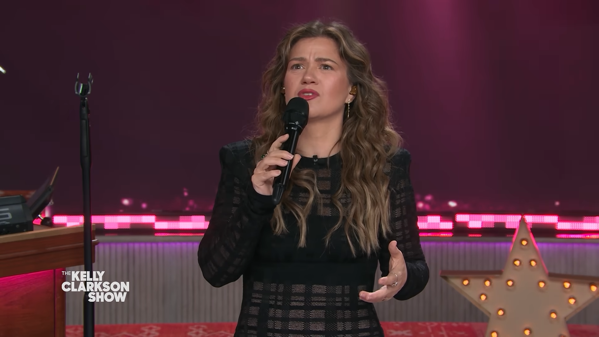 Kelly Clarkson 1 Kelly Clarkson holding a mic and looking confused