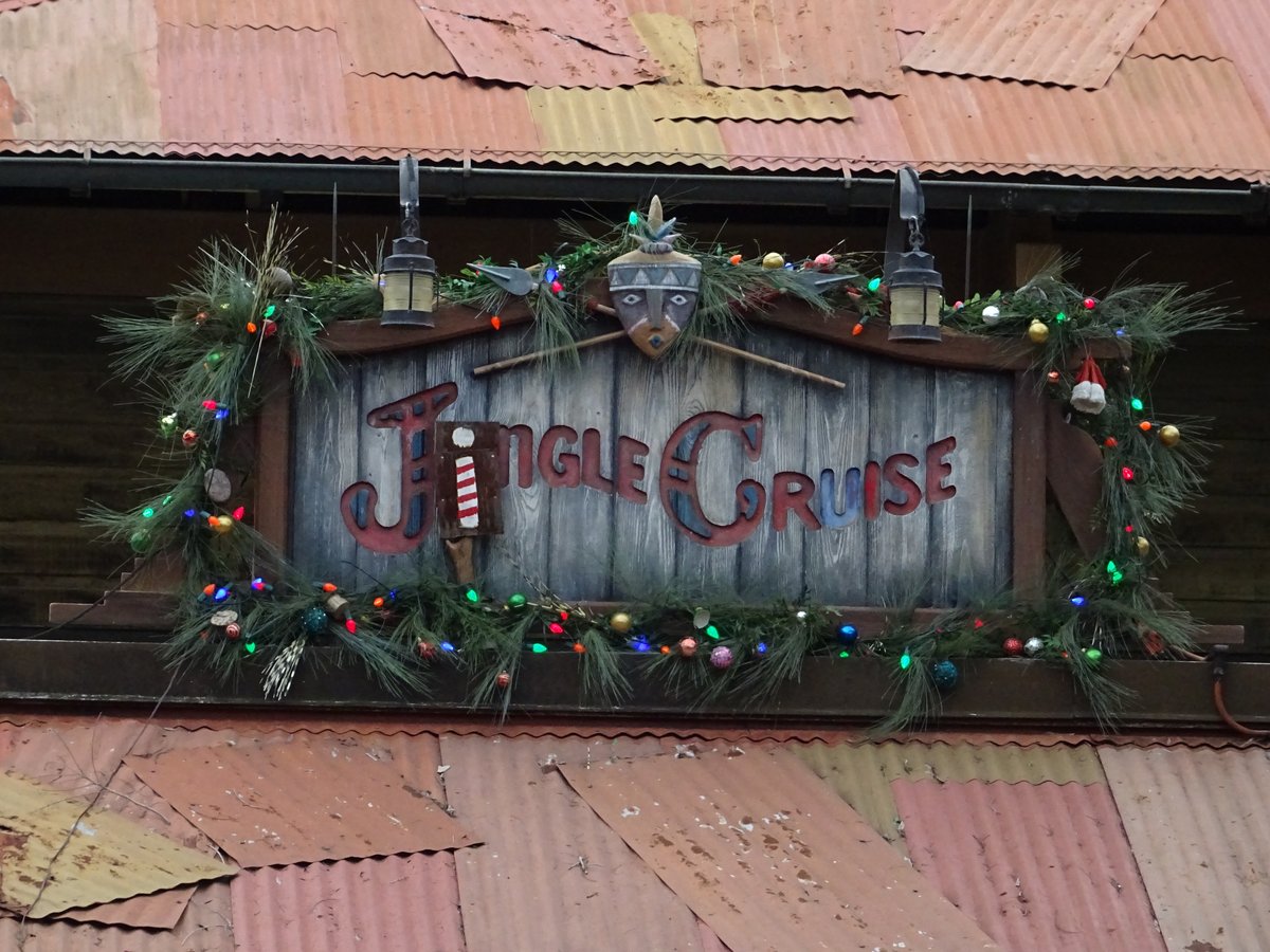 Wooden Jingle Cruise sign framed with garland and colored lights at the Magic Kingdom boathouse