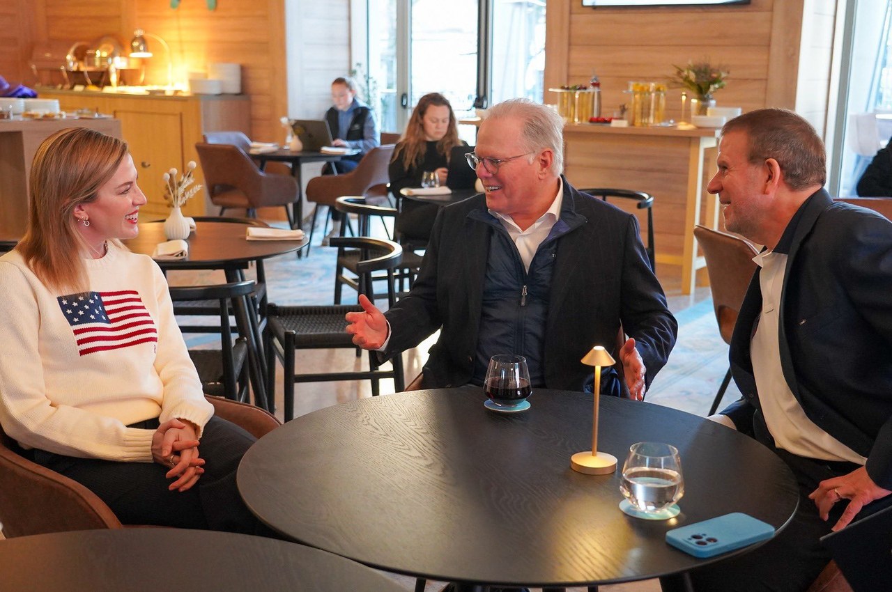 David Zaslav seated at a table talking with two people