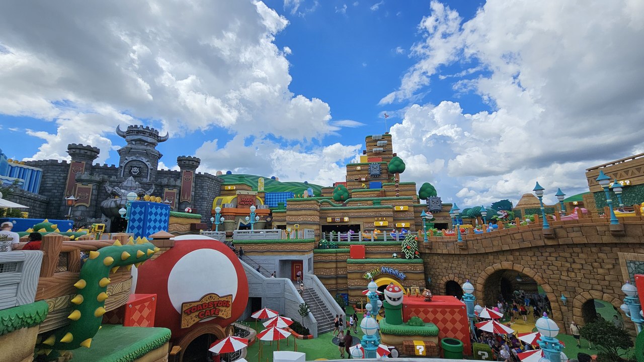 Colorful Super Nintendo World buildings and pipes under a blue sky at Epic Universe
