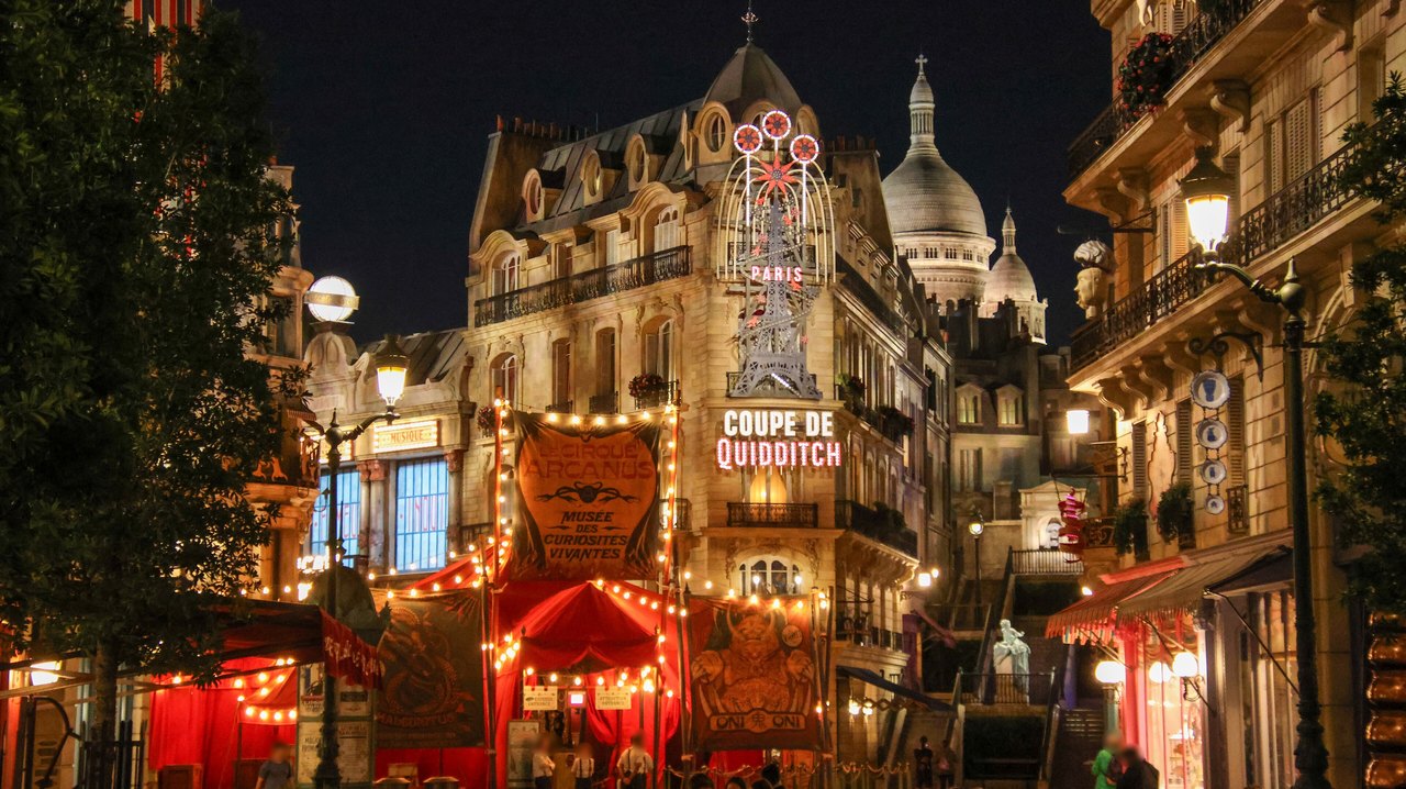 The Ministry of Magic area of Epic Universe lit up at night with ornate Parisian-style buildings