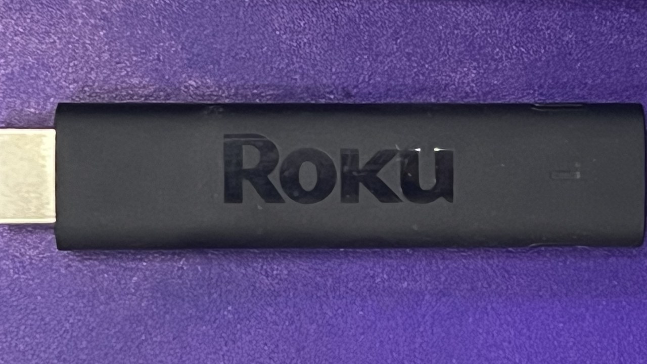 A black Roku Streaming Stick 4K on a purple background