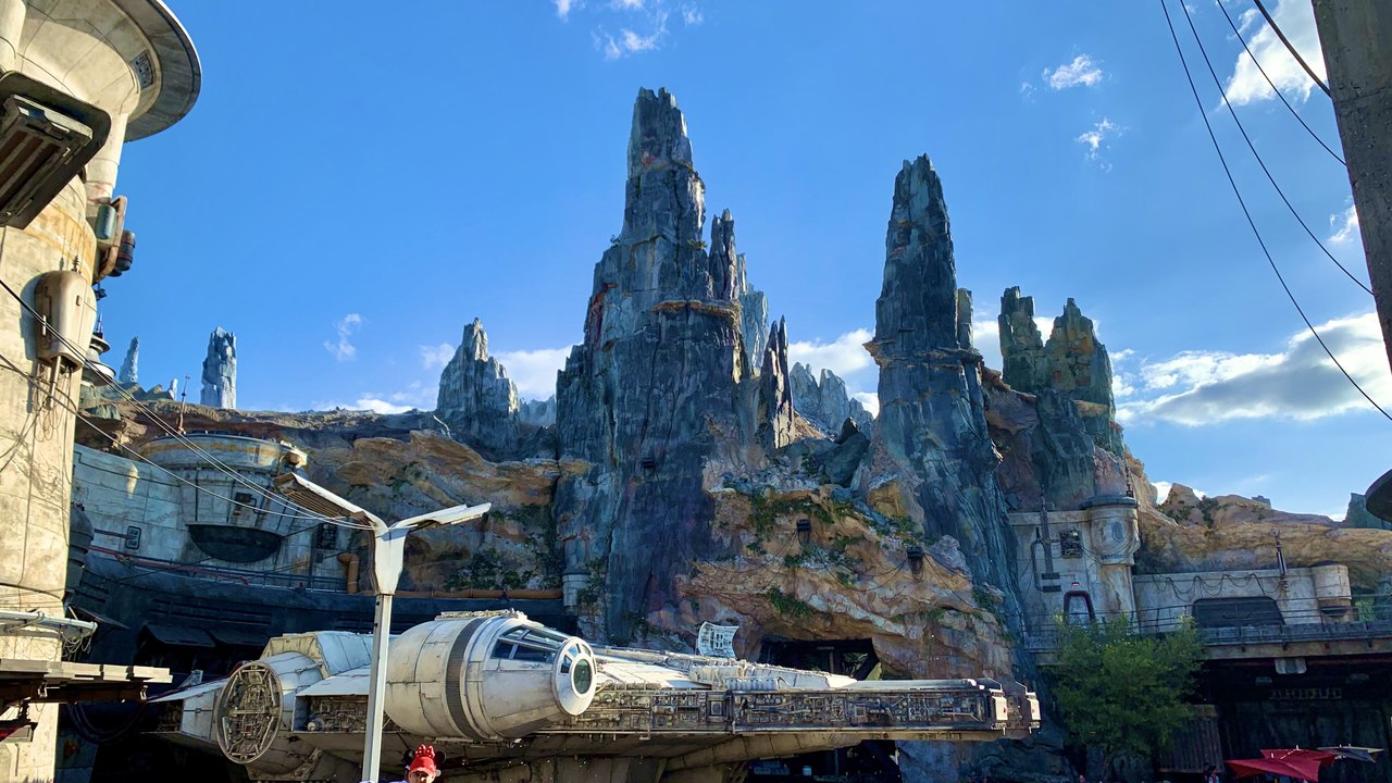 The Millennium Falcon parked beneath tall rock spires in Galaxy's Edge