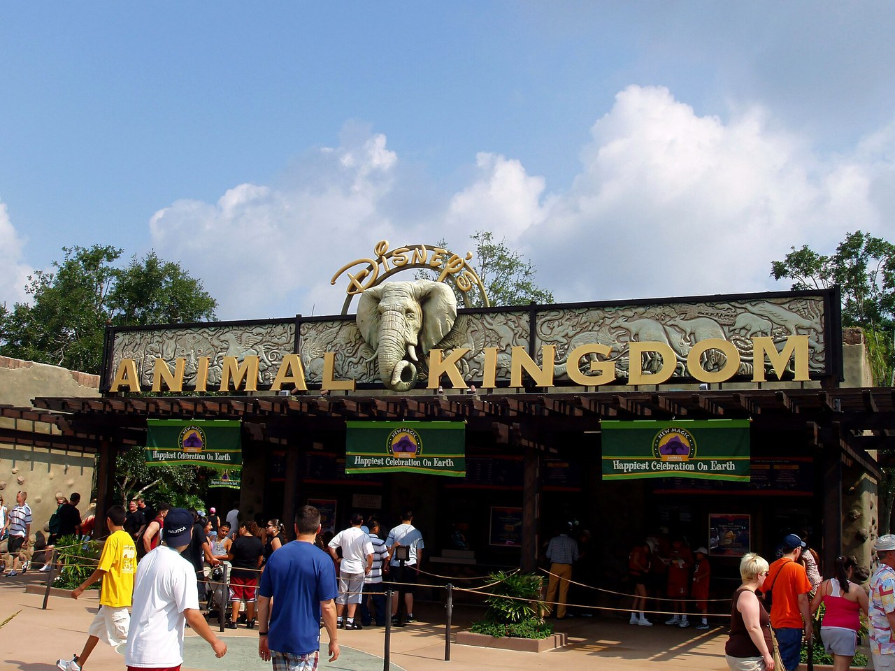 Guests walk beneath the Animal Kingdom sign at the park's front entrance