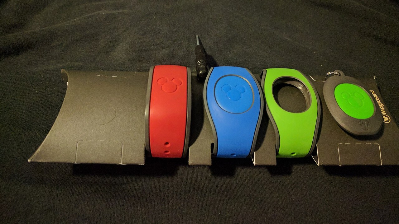 MagicBands lined up featured 1280×720 Four MagicBands in red, blue, green, and gray lined up on a dark cloth