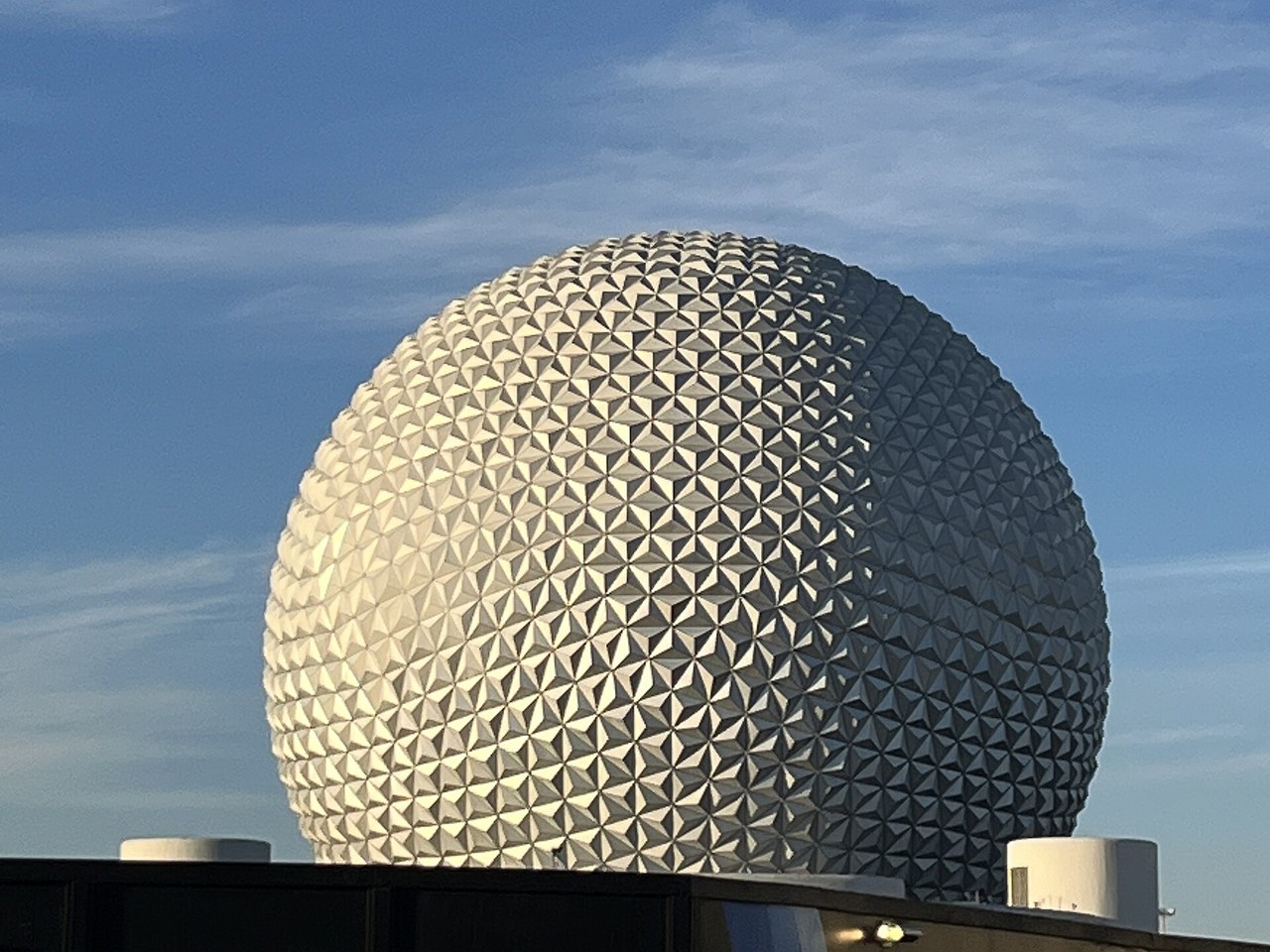 Spaceship Earth's silver geodesic sphere at EPCOT against a blue sky