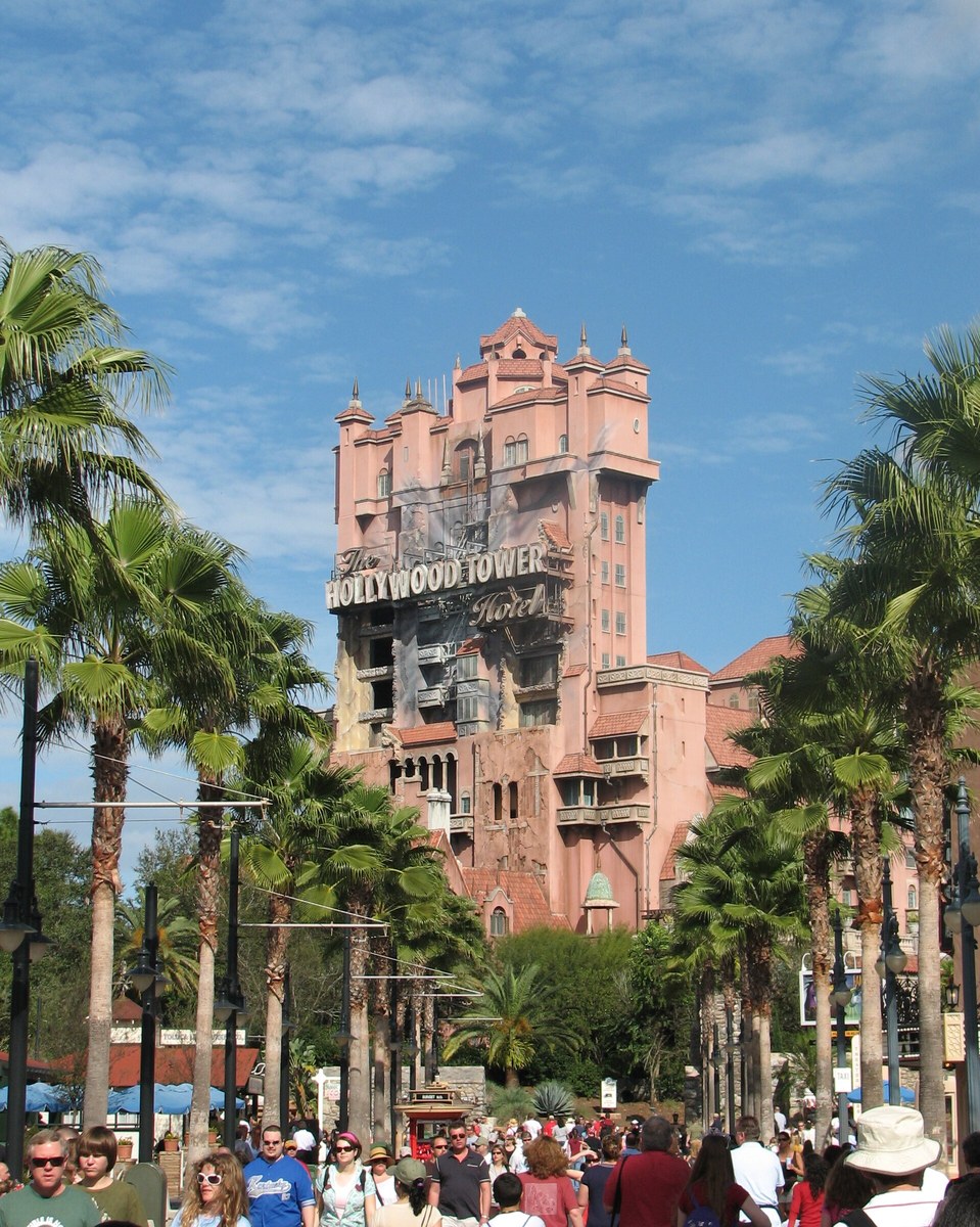 The pink and orange Hollywood Tower Hotel rising above palm trees at Disney's Hollywood Studios