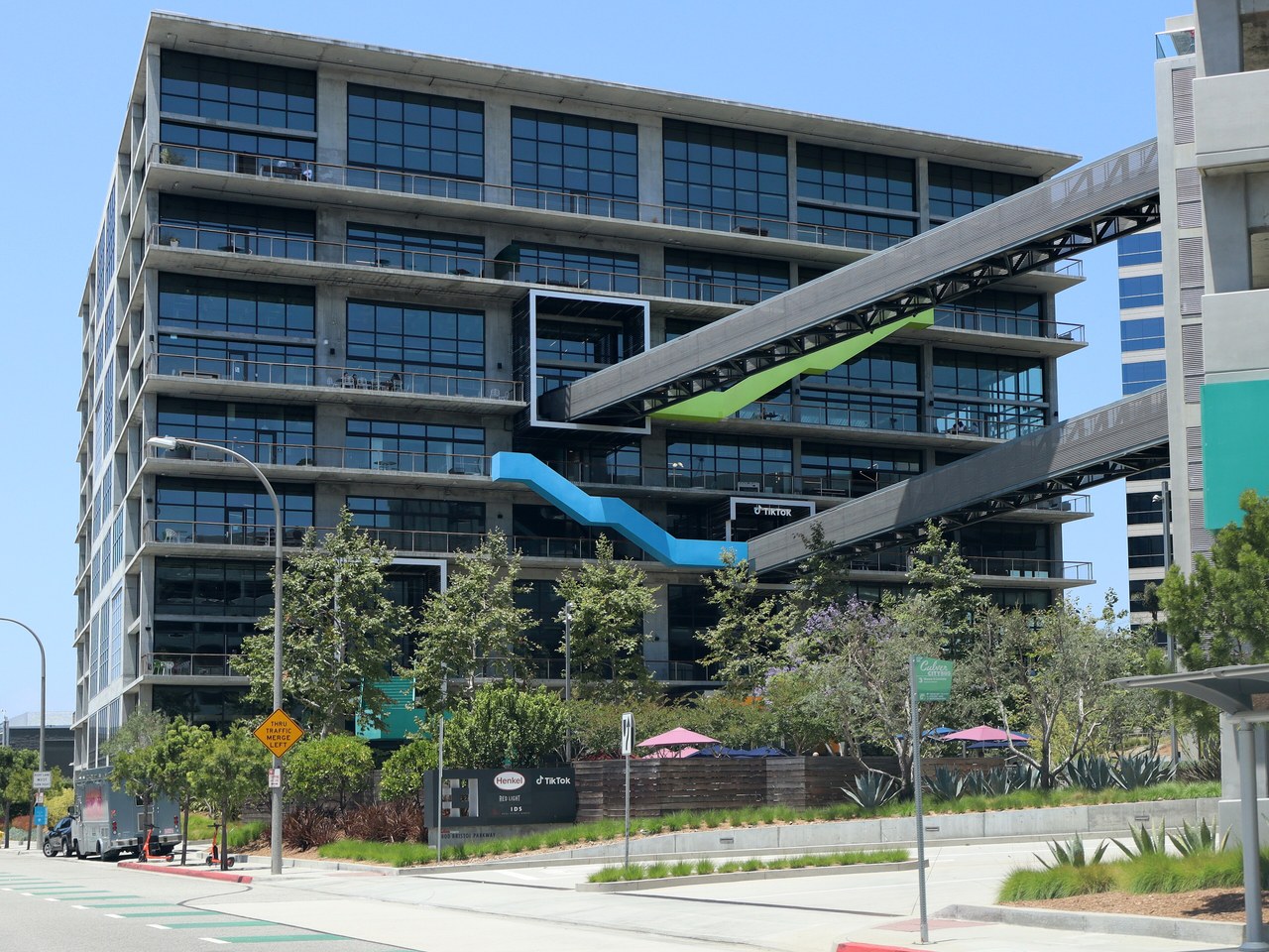 A modern glass office building with a colorful walkway in Culver City, California