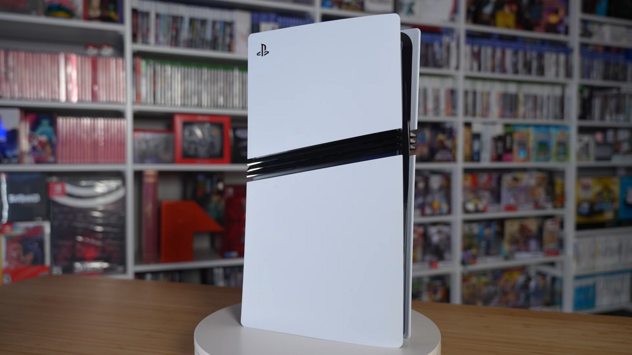 A white PS5 Pro console standing upright in front of shelves of video games