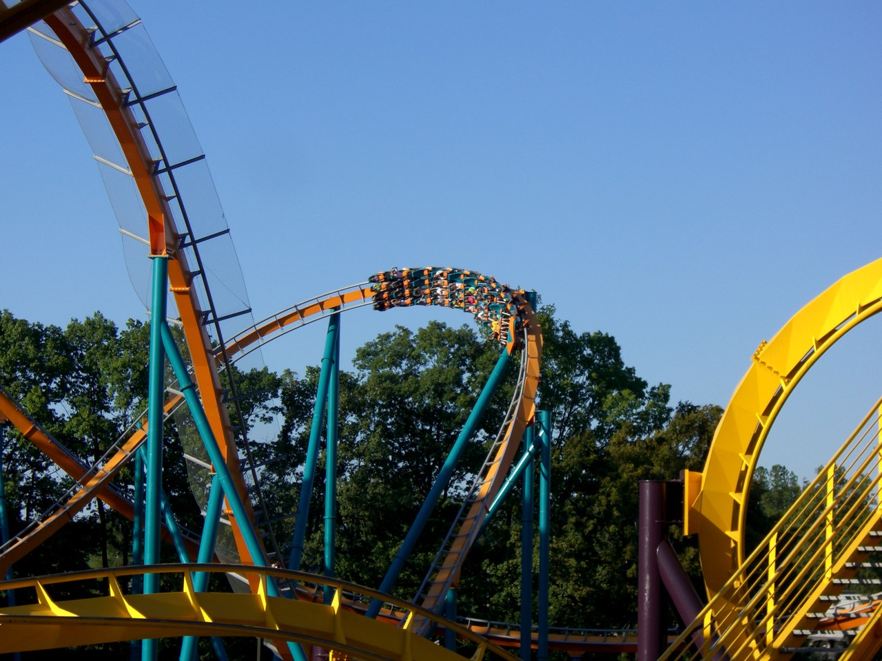 Goliath's orange and teal track twisting through the trees at Six Flags Over Georgia