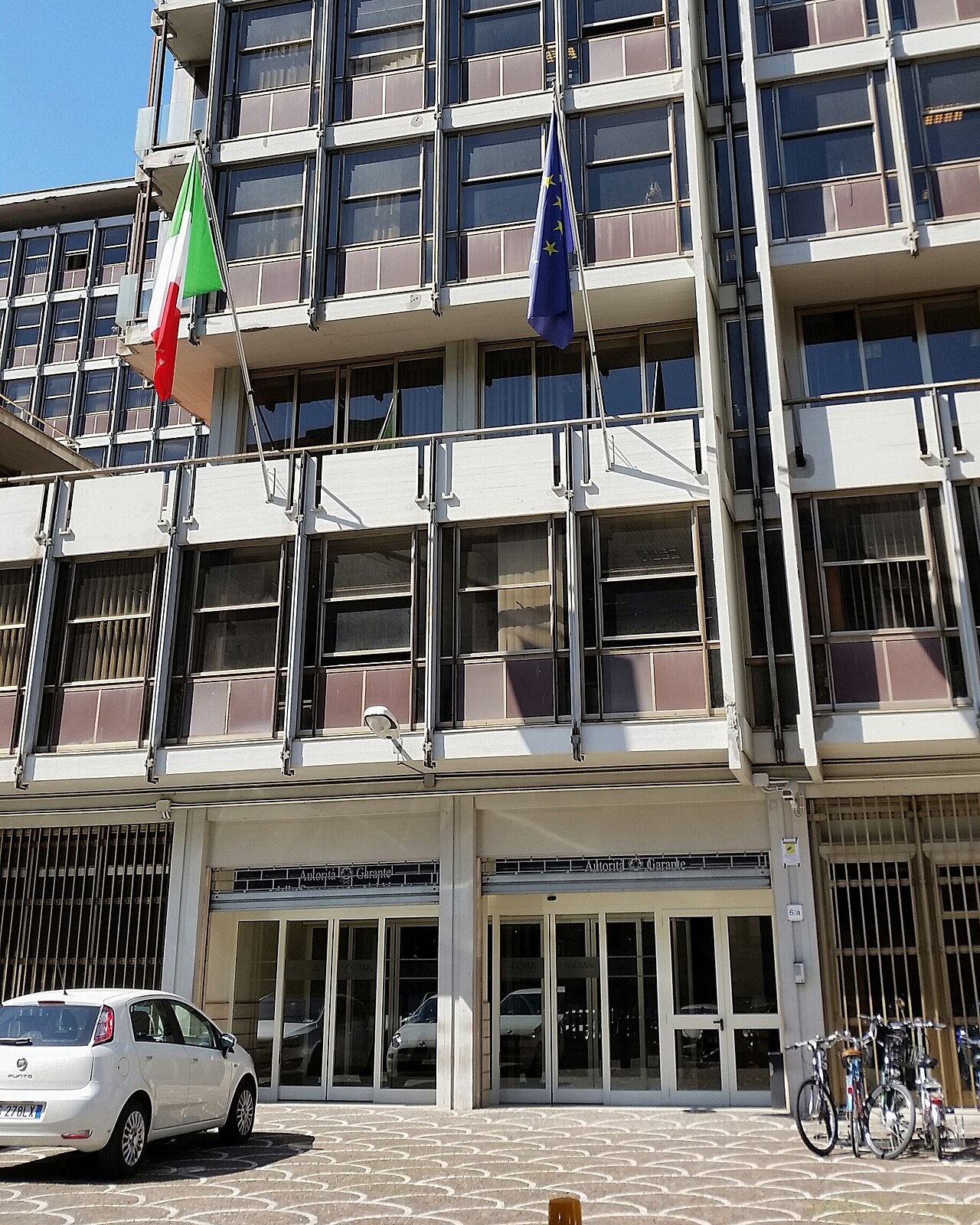 Headquarters of Italy's competition authority in Rome, with Italian and European Union flags over the entrance