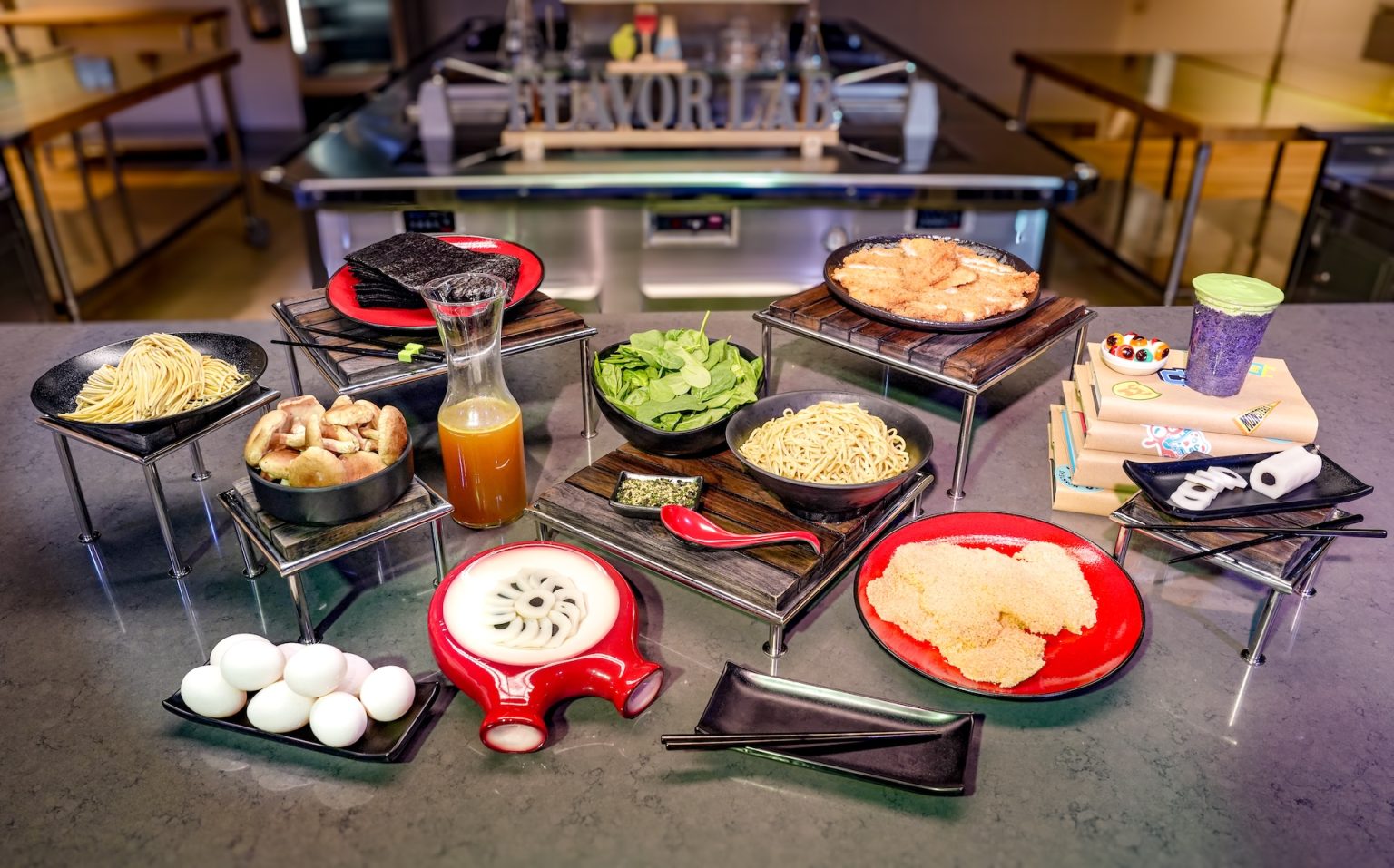 Ramen noodles, broth, mushrooms, spinach, nori, eggs, and other ingredients laid out on a counter in Disney's Flavor Lab